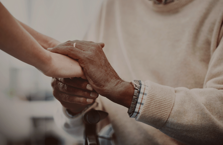 elderly person in a KYN care home holding hands with an admiral nurse